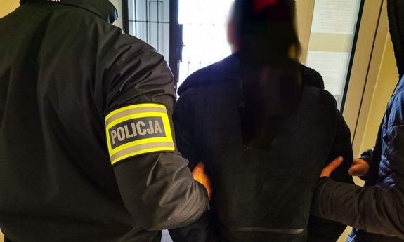 dwaj policjanci prowadzą zatrzymaną kobietę