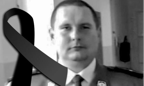 śp. asp. Marcin Opoński policjant Komendy Miejskiej Policji w Olsztynie w mundurze, z lewej strony zdjęcia kir żałobny