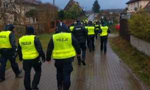 duża grupa policjantów idących drogą