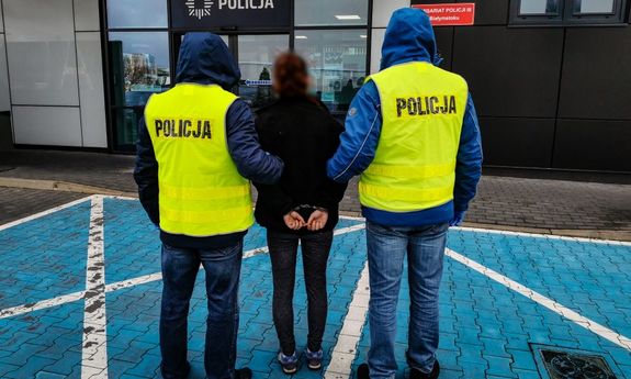 Policjanci prowadzą zatrzymanego