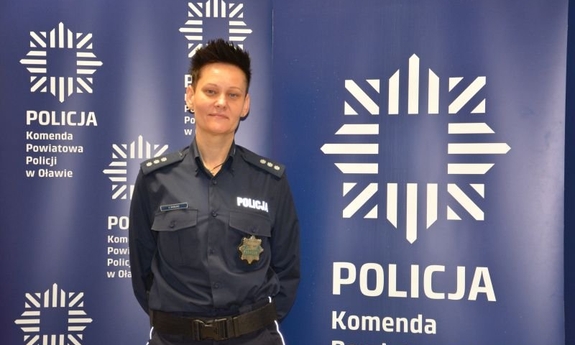 Na zdjęciu komisarz Agnieszka Borejko na tle baneru Komedy Powiatowej Policji w Oławie