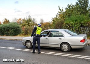 Policjant ruchu drogowego  wskazujący kierowcy drogę