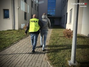 policjant prowadzi zatrzymanego mężczyznę