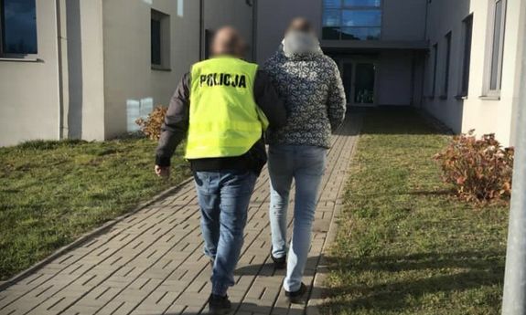 policjant prowadzi zatrzymanego mężczyznę