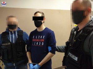 dwaj policjanci z zatrzymanym mężczyzną