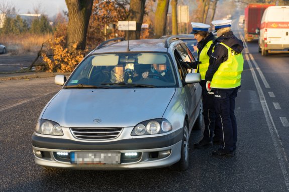 policjanci ruchu drogowego kontrolują kierowcę auta