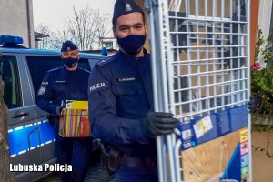 policjanci niosą zebrane przedmioty&quot;&gt;