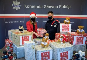 pracownica cywilna policji oraz policjant wśród paczek świątecznych