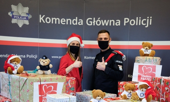 pracownica cywilna policji oraz policjant wśród paczek świątecznych