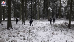 policjanci prowadzący poszukiwania w lesie