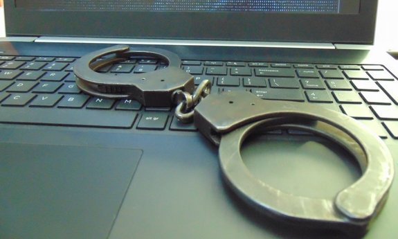 kajdanki leżące na klawiaturze laptopa