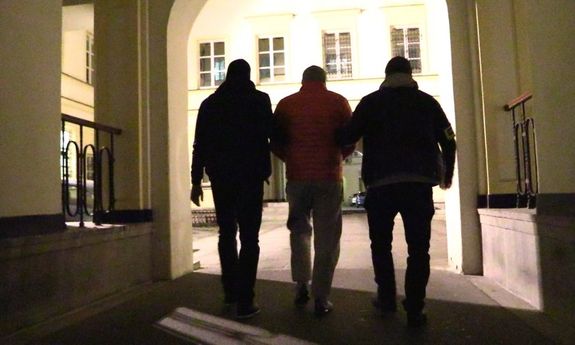 Policjanci prowadzą zatrzymanego mężczyznę