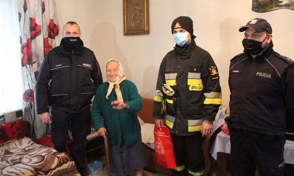 Strażacy, policjanci  z mieszkanką, u której zamontowano czujnik