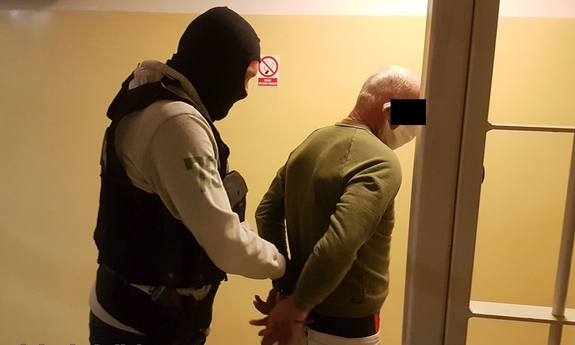 policjant prowadzi zatrzymanego mężczyznę