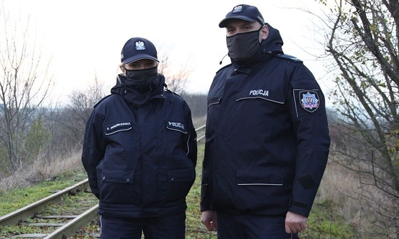policjant i policjantka stoją przy torach kolejowych