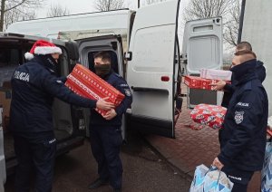 Policjanci pakują paczki do samochodu