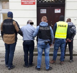 Policjanci prowadzą zatrzymanych mężczyzn do Prokuratury Rejonowej w Nakle nad Notecią.