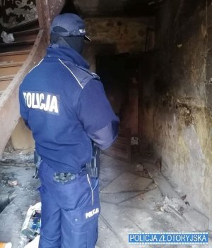 Na zdjęciu policjant sprawdza pustostan