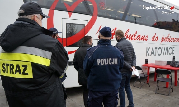 policjanci i strażacy przed krwiobusem w oczekiwaniu na oddanie krwi