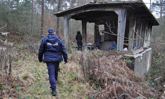 Na zdjęciu policjant sprawdza opuszczone miejsca i osoby bezdomne.