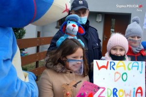 Dziecko prezentuje transparent Wracaj do zdrowia