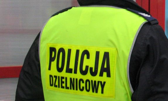 Na zdjęciu policjant w kamizelce odblaskowej z napisem policja, dzielnicowy