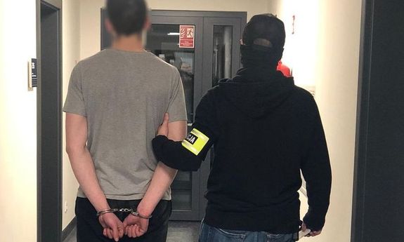 policjant prowadzi zatrzymanego