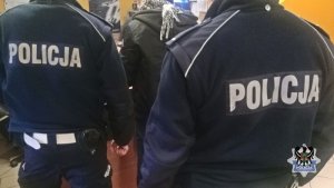 Policjanci prowadzą zatrzymanego