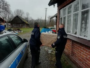 Policjanci przekazują świąteczne paczki