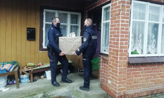 Policjanci przekazują świąteczne paczki