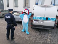 Sznupek wraz z umundurowanym policjantem stoją przy jednym z domów