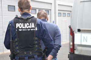 Policjant prowadzi zatrzymanego