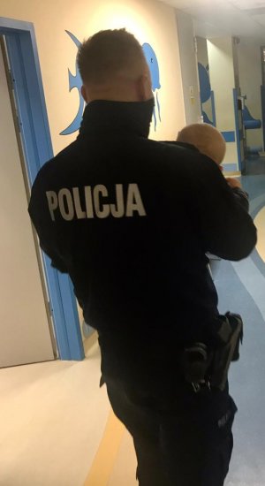 policjant z dzieckiem na rękach