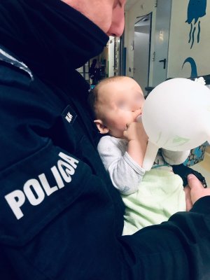 policjant z dzieckiem na rękach