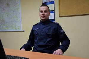 Młodszy aspirant Kamil Sowa siedzi przy biurku