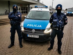 umundurowani policjanci z białostockiej patrolówki, którzy stoją przed oznakowanym radiowozem