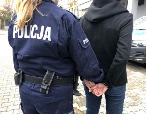 policjantka prowadzi zatrzymanego