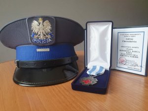 Czapka munduru galowego policjanta oraz medal Honorowy Dawca Krwi - Zasłużony dla Zdrowia Narodu