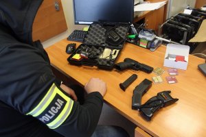 Policjant rozłożył na biurku broń gazową, dwa paralizatory i walizkę od broni