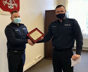 Zastępca Komendanta Miejskiego Policji w Koszalinie nadkom. Marcin Pilarczyk wręcza policjantowi podziękowanie