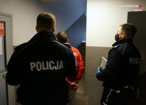 dwaj policjanci z zatrzymanym mężczyzną