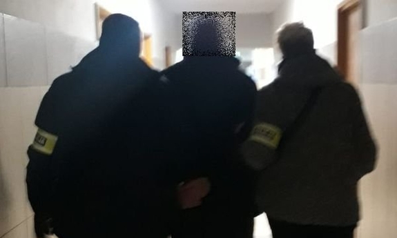 dwaj policjanci prowadzą zatrzymanego