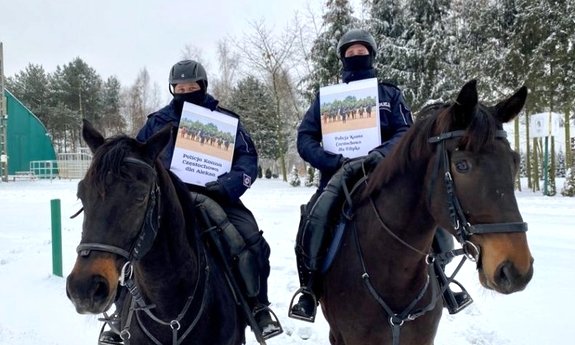 policjanci na koniach służbowych, w ręce trzymają kalendarz przeznaczony na aukcje