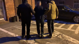 dwaj policjanci prowadzą zatrzymanego