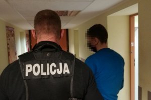 policjant prowadzi zatrzymanego mężczyzna