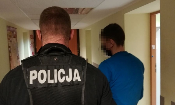 policjant prowadzi zatrzymanego mężczyzna