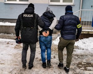 dwaj policjanci prowadzą zatrzymanego