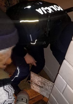 Policjant w mundurze rozpala w piecu
