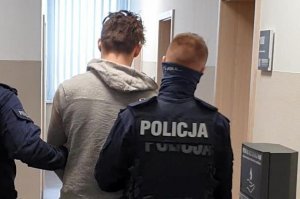 policjant prowadzi zatrzymanego