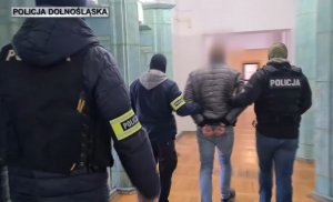 policjanci prowadzą zatrzymanego